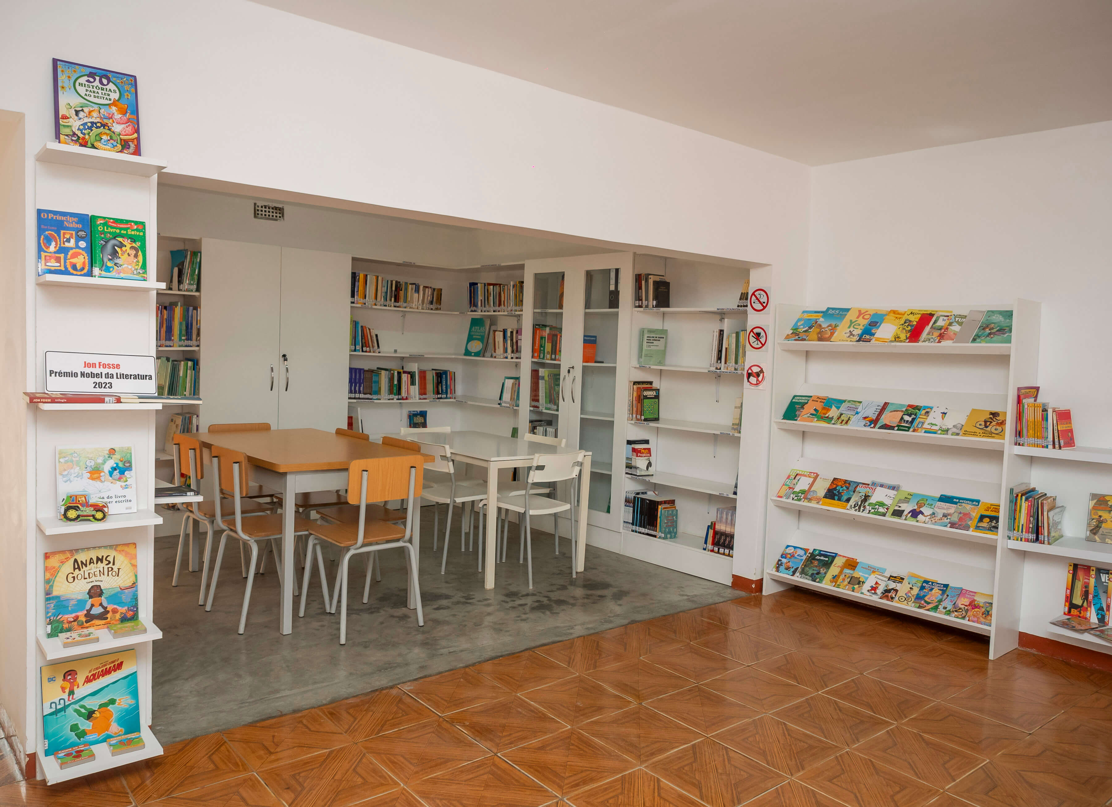 Crianças lendo livros na sala principal da Biblioteca Marta Domingos